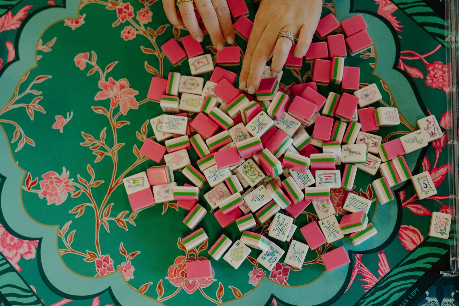 Colorful pink mahjong tiles on a green floral mat