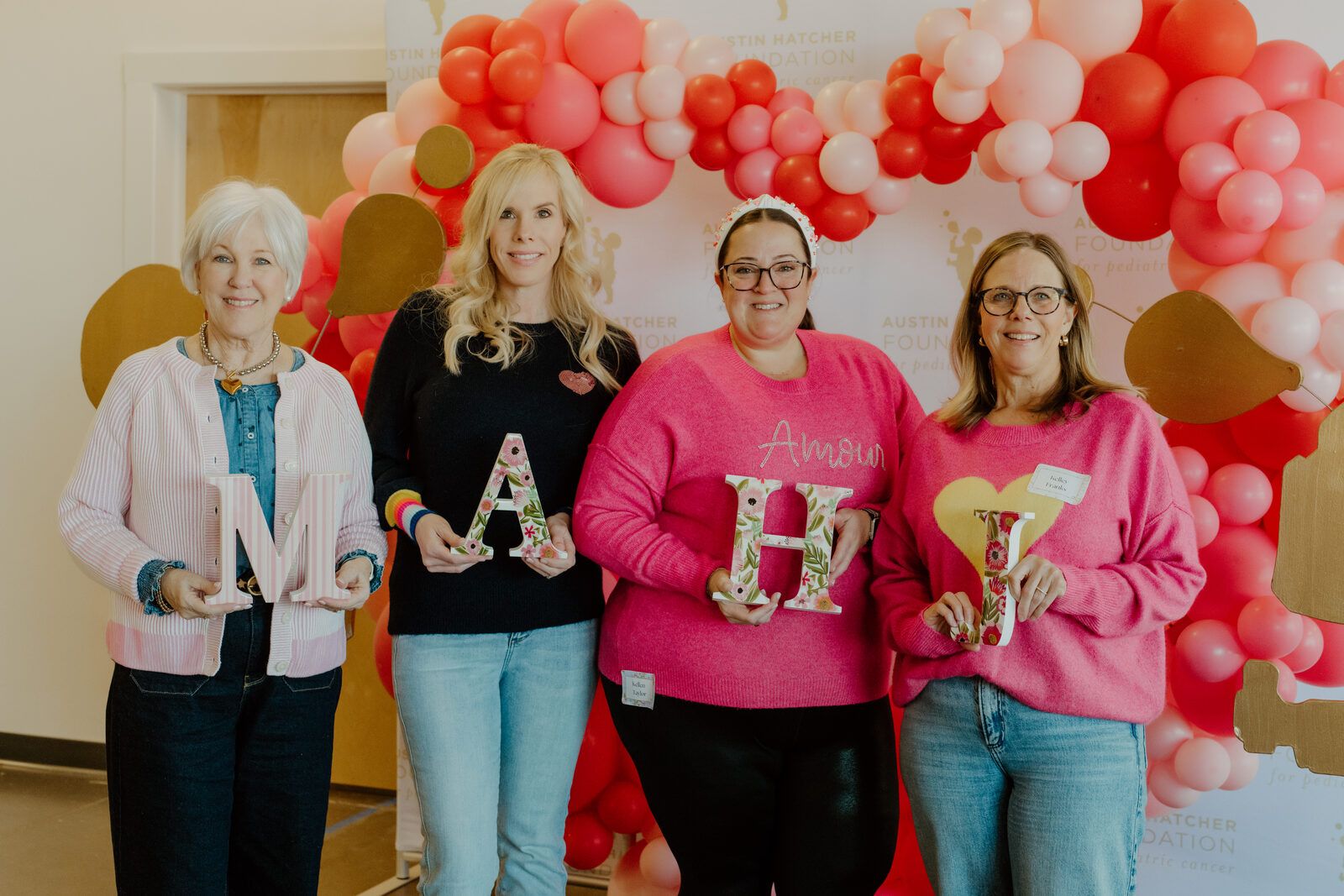 Mahj For A Cause volunteers holding MAHJ letters